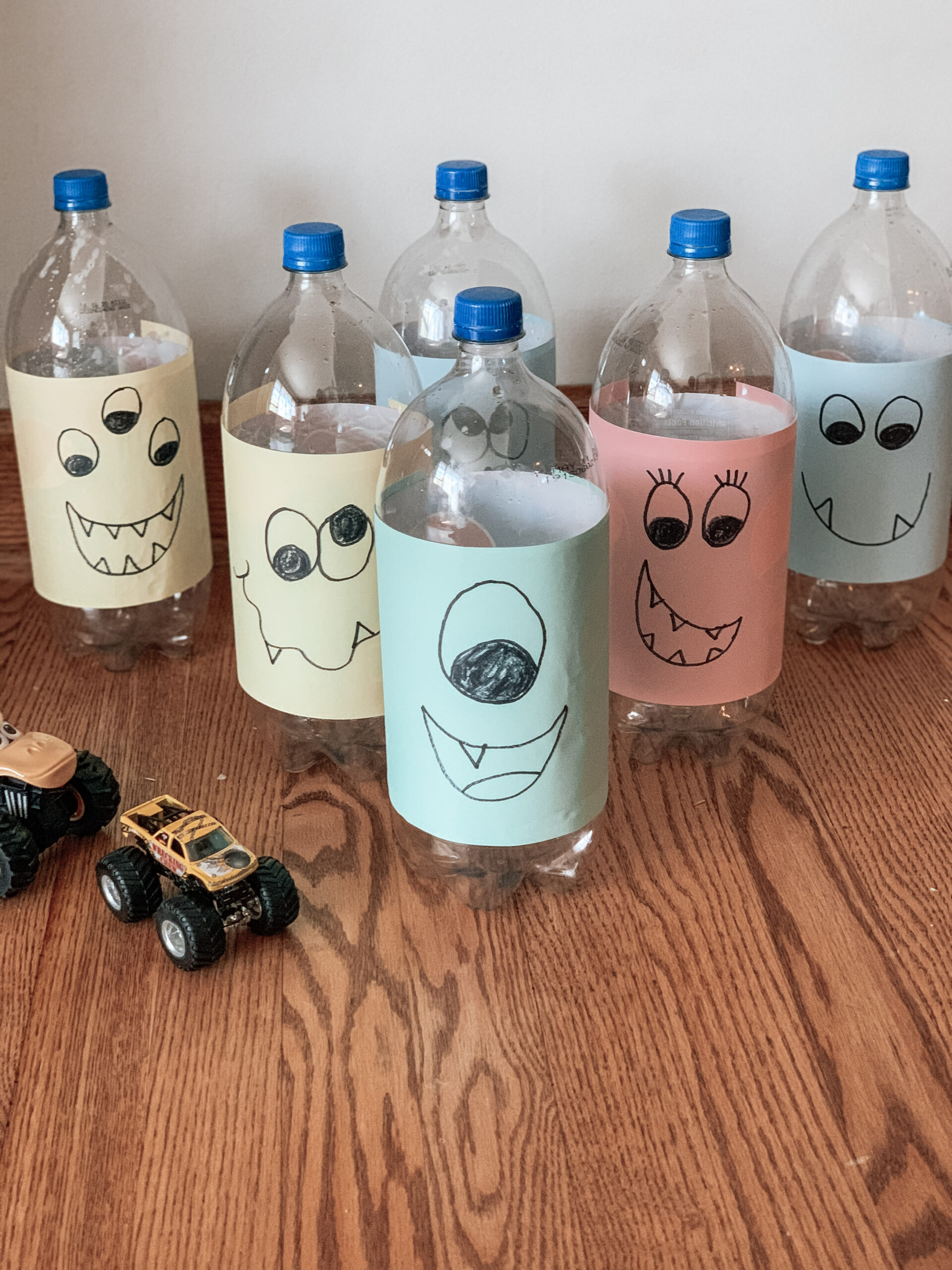 Completed repurposed monster bowling kid activity. Shows how to reuse bottles and monster truck toys.