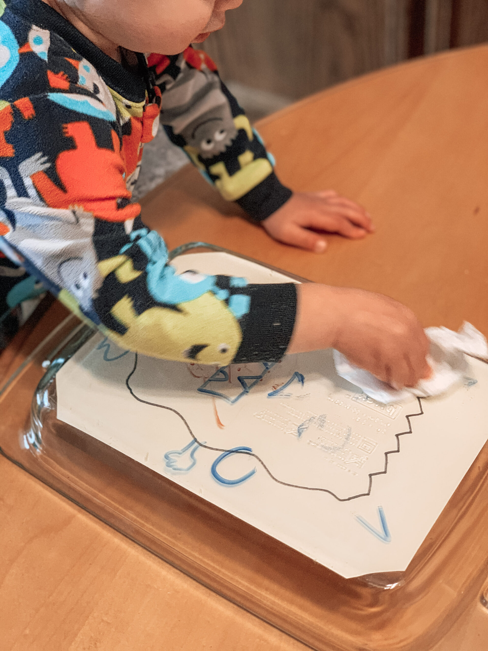 Child playing with repurposed monster craft. Kid is showing how to wipe off monster faces with activity.