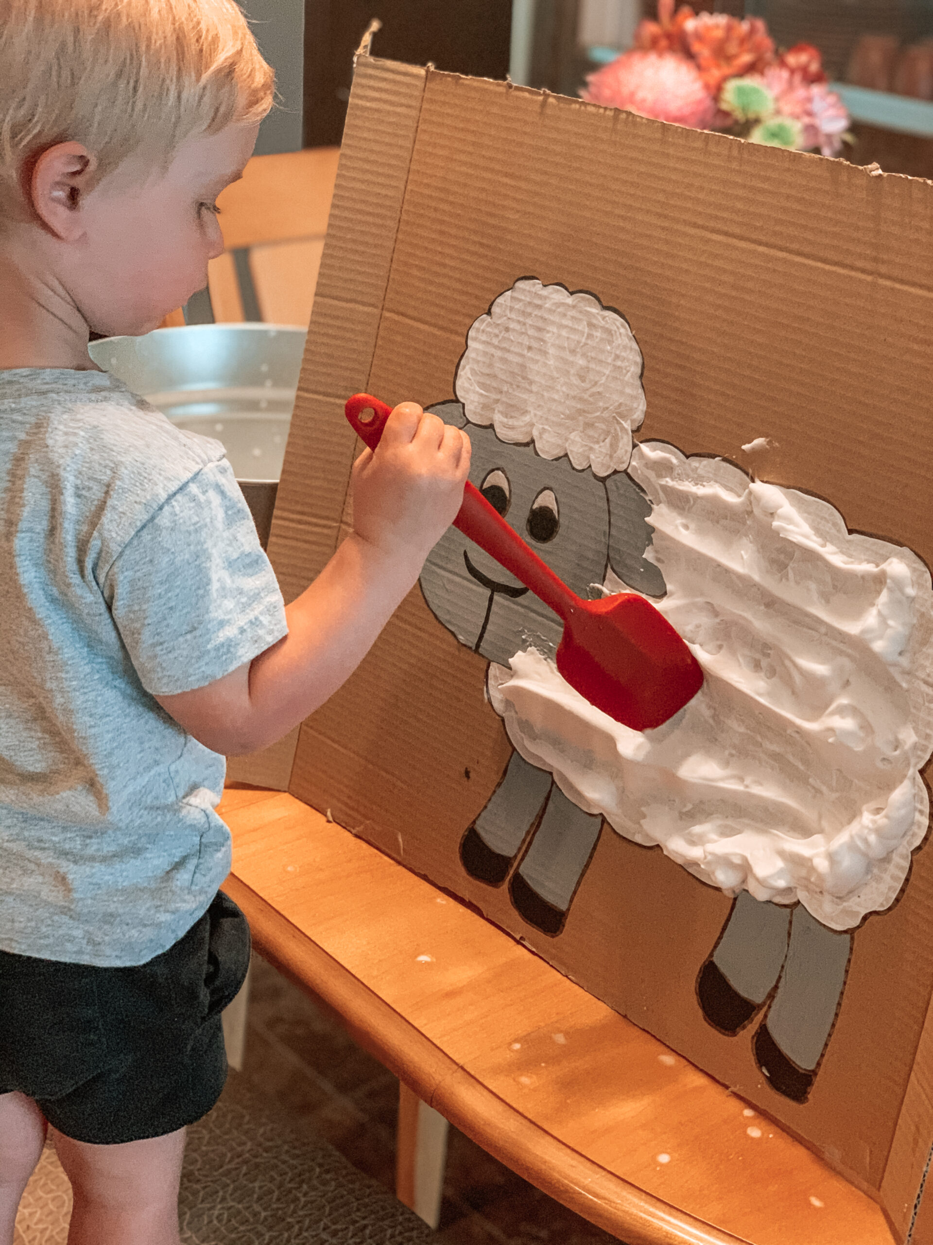 child playing with shaving cream sheep